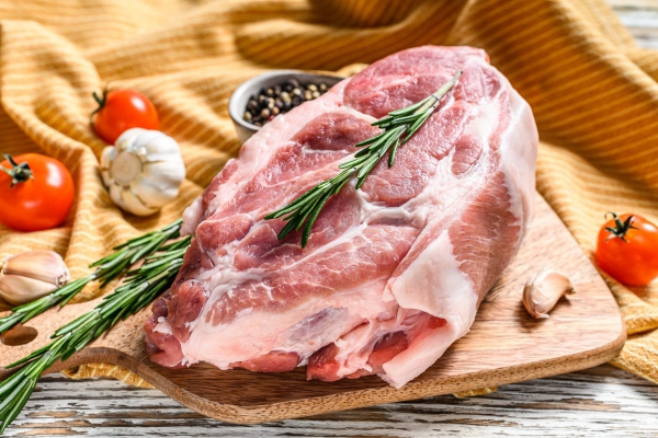 Raw pork neck chop meat with herb leaves and spices. White background. Top view